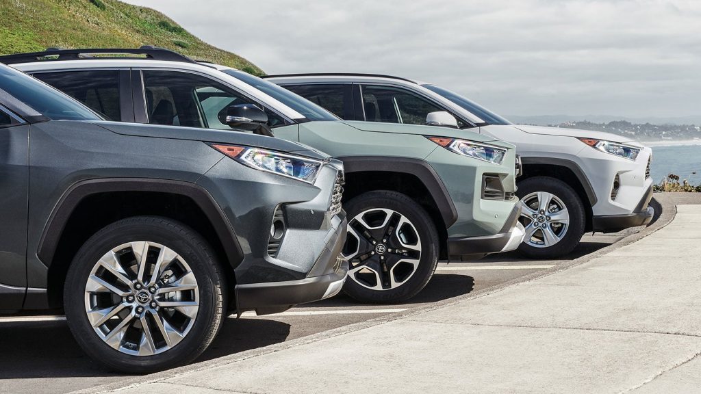 Three Toyota SUVs parked side by side near a coastal overlook with ocean views in the background.