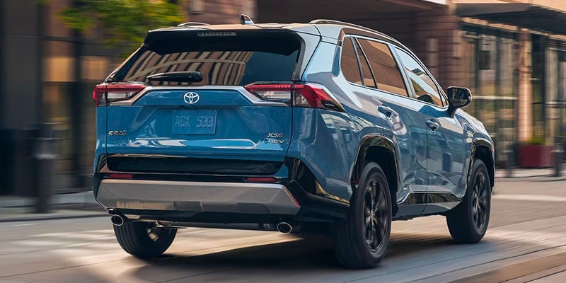 The rear of a 2025 Toyota RAV4 Hybrid driving away with its engine power in Pleasant Hills, PA